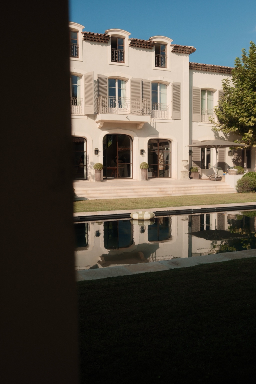 Private residence and estate management: a Provençal villa with grey shutters reflected in a long pool